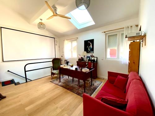 - un salon avec un canapé rouge et un tableau noir dans l'établissement Chez Olivier, à Montreuil
