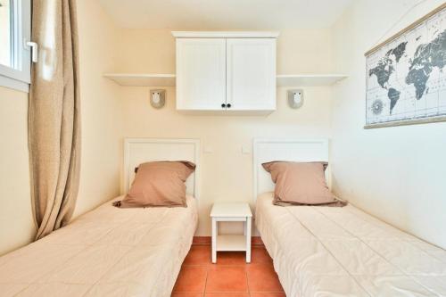 - 2 lits dans une petite chambre avec une table dans l'établissement Village Pont Royal en Provence - maeva Home - Appartement 2 pièces 4 personnes - Sélection MAE-2964, à Mallemort