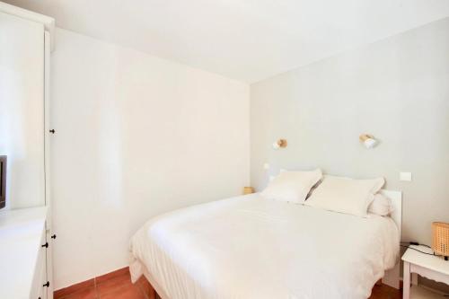 une chambre blanche avec un lit et une table dans l'établissement Village Pont Royal en Provence - maeva Home - Appartement cosy et climatisé 3 pièces 5 personnes avec balcon - Sélection - super Home MAE-3314, à Mallemort
