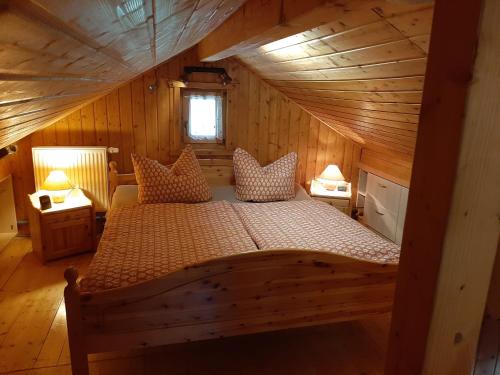 ein Schlafzimmer mit einem Bett in einer Holzhütte in der Unterkunft Ferienhaus Obert - Drognitz in Drognitz