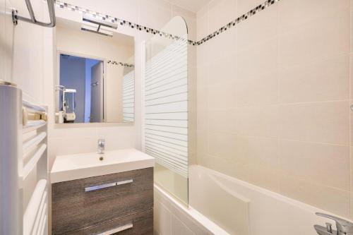 a bathroom with a sink and a tub and a mirror at Les maisons de Port Guillaume - maeva Home - Maison 3 pièces 6 personnes - Confort MAE-3464 in Dives-sur-Mer