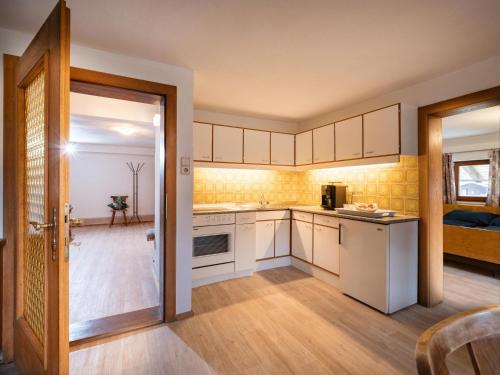 a kitchen with white cabinets and a door leading to a bedroom at Urlaub am Stoffenhof in Wörgl