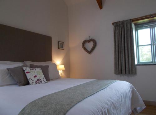 A bed or beds in a room at The Barn At Collacott