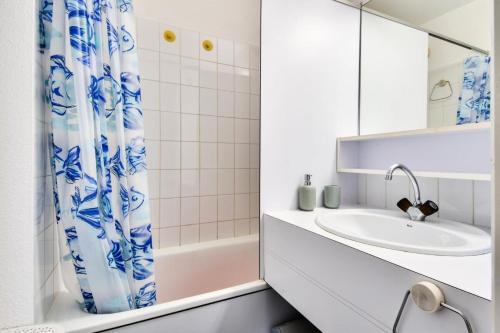 une salle de bain avec un lavabo et un rideau de douche dans l'établissement Résidence Port Bourgenay - maeva Home - Appartement 2 pièces 5 personnes - Sélection MAE-6174, à Talmont-Saint-Hilaire