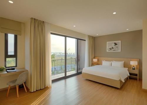 1 dormitorio con 1 cama grande y balcón en Kim's Villa - 5 phòng ngủ siêu rộng - 100m đến Bãi Tắm, en Ha Long