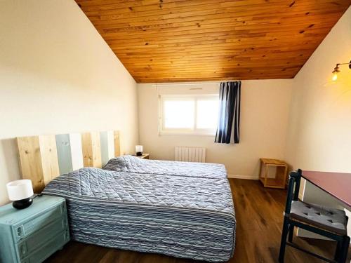 sypialnia z łóżkiem i drewnianym sufitem w obiekcie Résidence Le Boucanier - 2 Pièces pour 6 Personnes 964 w mieście Vieux-Boucau-les-Bains