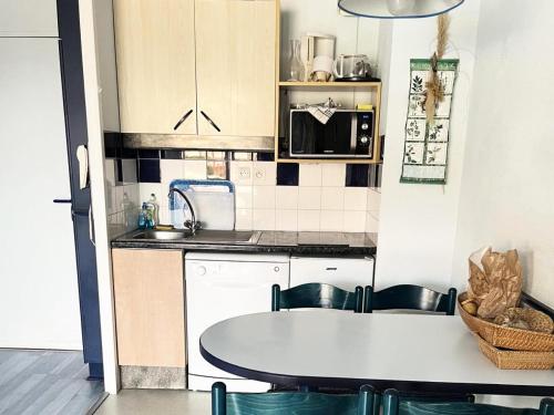une cuisine avec une table, des chaises et un évier dans l'établissement Résidence Le Boucanier - 2 Pièces pour 4 Personnes 024, à Vieux-Boucau-les-Bains