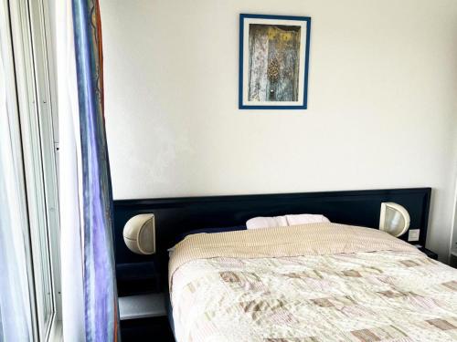 - une chambre avec un lit et une photo sur le mur dans l'établissement Résidence Le Boucanier - 2 Pièces pour 4 Personnes 024, à Vieux-Boucau-les-Bains