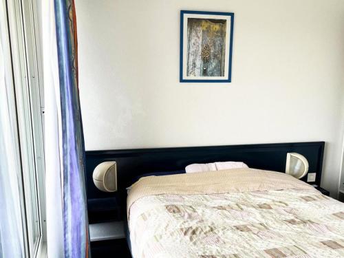 une chambre avec un lit et un tableau au mur dans l'établissement Résidence Le Boucanier - 2 Pièces pour 4 Personnes 024, à Vieux-Boucau-les-Bains