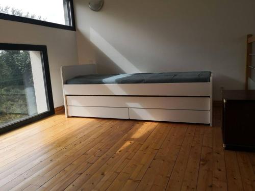 une chambre avec un lit et un parquet dans l'établissement Appartement accueillant au cœur de Le Conquet avec parking privé, au Conquet