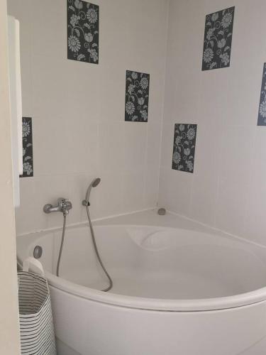 une baignoire blanche avec douche dans une salle de bain dans l'établissement Maison accueillante au cœur du Conquet avec parking privé, au Conquet