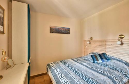 une chambre avec un lit avec une tête de lit en bois dans l'établissement Village Pont Royal en Provence - maeva Home - Appartement charmant et climatisé 2 pièces 4 personnes - Prestige - super Home MAE-4884, à Mallemort