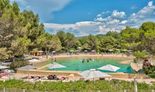 - une grande piscine avec des parasols dans l'établissement Village Pont Royal en Provence - maeva Home - Appartement charmant et climatisé 2 pièces 4 personnes - Prestige - super Home MAE-4884, à Mallemort