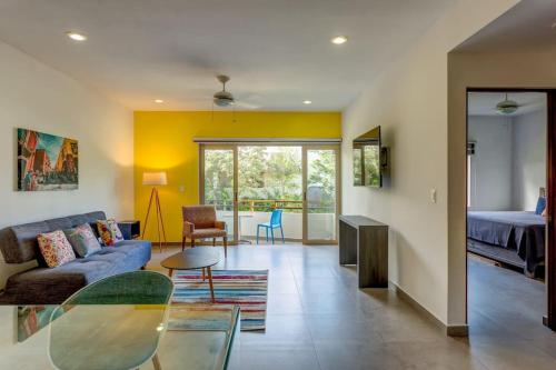 sala de estar con sofá y mesa en Condo Complex with an Alluring Pool & Tropical Vibes by Stella Rentals, en Tulum