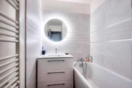 une salle de bain avec un lavabo, une baignoire et un miroir dans l'établissement Village Pont Royal en Provence - maeva Home - Appartement 3 pièces 6 personnes - Prestige MAE-4874, à Mallemort