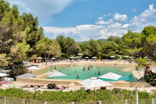 - une grande piscine avec des parasols dans l'établissement Village Pont Royal en Provence - maeva Home - Appartement 3 pièces 6 personnes - Prestige MAE-4874, à Mallemort