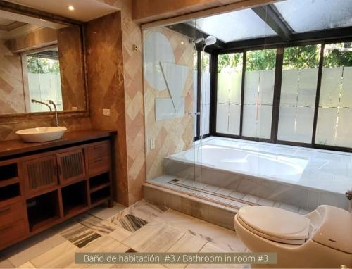 a bathroom with a tub and a toilet and a sink at Finca el Castillo Copacabana. Top 1 en Fincas! in Copacabana