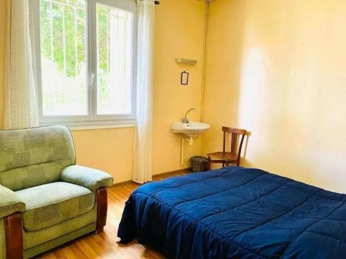 une chambre avec un lit, une chaise et une fenêtre dans l'établissement Cost, à Valras-Plage