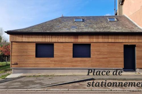 un bâtiment avec une enseigne sur le côté dans l'établissement Le Pont Joly, à Saint-Philbert-sur-Risle