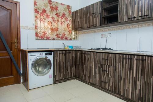 a kitchen with a washing machine in a kitchen at EdenRose home in Kwabenyan