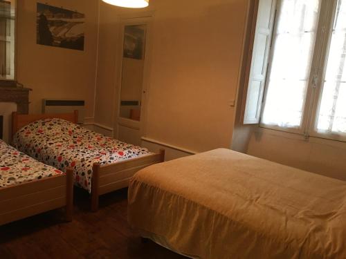 a bedroom with two beds and a window at Palais d'étigny in Luchon
