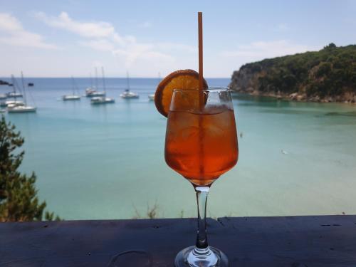 a drink sitting on a table with an orange slice in it at Bei Kosta in Mesopótamon