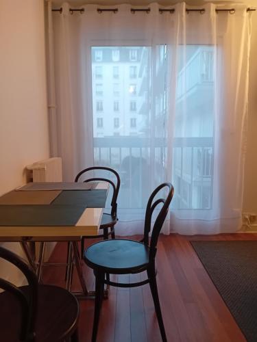 une salle à manger avec une table et des chaises et une fenêtre dans l'établissement Au rendez vous, à Paris