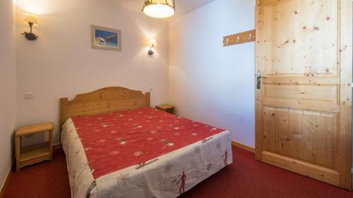 - une chambre avec un lit et une porte en bois dans l'établissement A104 - Appartement 2 pieces 4 personnes, à Orcières