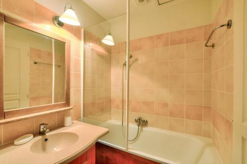 La salle de bains est pourvue d'un lavabo, d'une baignoire et d'une douche. dans l'établissement La résidence du Lac - maeva Home - Appartement 2 pièces 5 personnes - Sél 674, à Monflanquin