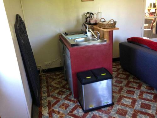 eine Küche mit einem Waschbecken in der Ecke eines Zimmers in der Unterkunft Appartement d'une chambre avec wifi a Bourg le Comte in Bourg-le-Comte