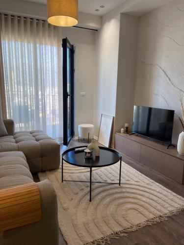 een woonkamer met een bank en een salontafel bij Square INN Garden Aparthotel in Tirana