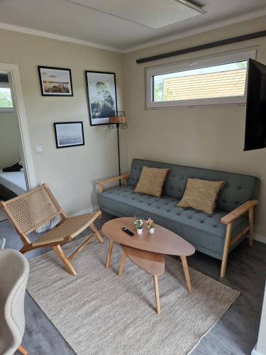 a living room with a blue couch and a table at NordicFreya in Belau