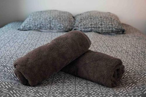 - un lit avec deux oreillers et une serviette brune dans l'établissement Studio cosy/Parking/Jardin, à Toulouse