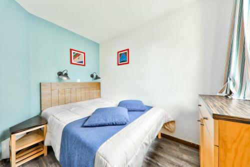 une chambre avec un lit avec une couverture bleue dans l'établissement Résidence Port du Crouesty - maeva Home - Appartement 2 pièces 5 personnes - Confort - vue Mer MAE-0564, à Arzon