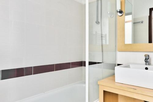 une salle de bain avec un lavabo et un miroir dans l'établissement Résidence Port du Crouesty - maeva Home - Appartement 2 pièces 5 personnes - Confort - vue Mer MAE-0564, à Arzon