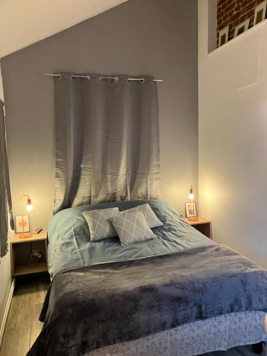 um quarto com uma cama com cabeceira e 2 candeeiros em La Marokanette em Saint-Maclou-de-Folleville