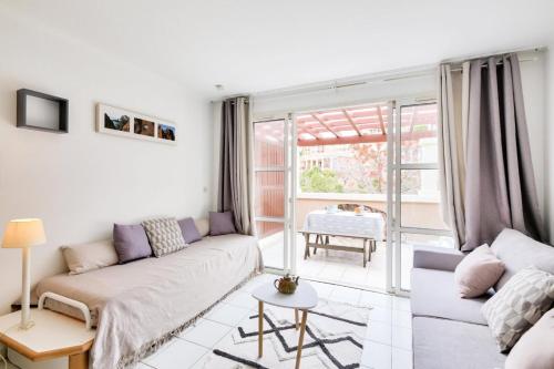 un salon avec un canapé et une table dans l'établissement Résidence le Village de Cap Esterel - maeva Home - Studio 4 personnes - Sélection MAE-8824, à Saint-Raphaël