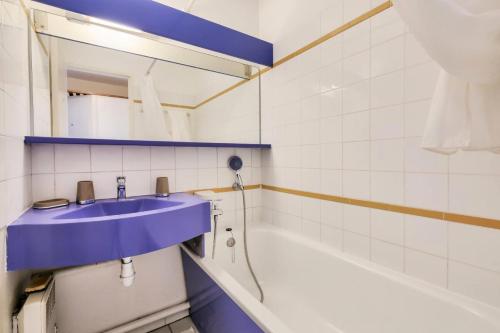 La salle de bains est pourvue d'un lavabo bleu et d'une baignoire. dans l'établissement Résidence le Village de Cap Esterel - maeva Home - Studio 4 personnes - Sélection MAE-8824, à Saint-Raphaël