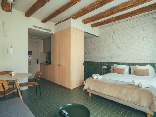 ein Schlafzimmer mit einem großen Bett und einem Tisch in der Unterkunft Boutique Apartments 23 Barcelona in Barcelona