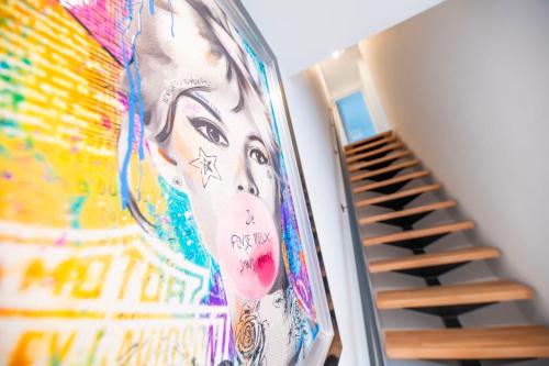 a painting of a woman on a wall next to a staircase at LA PARENTHESE in Tournai