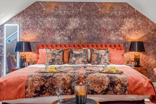 um quarto com uma cama grande com roupa de cama laranja em The Ley Arms em Exeter