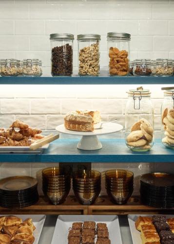 a shelf filled with lots of different types of pastries at Puente Colgante Boutique Hotel in Portugalete