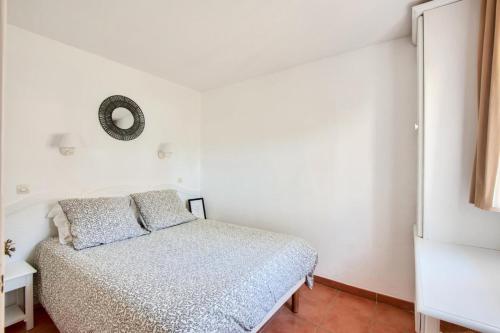 une chambre blanche avec un lit et un miroir dans l'établissement Village Pont Royal en Provence - maeva Home - Appartement 2 pièces 6 personnes - Sélection MAE-8854, à Mallemort