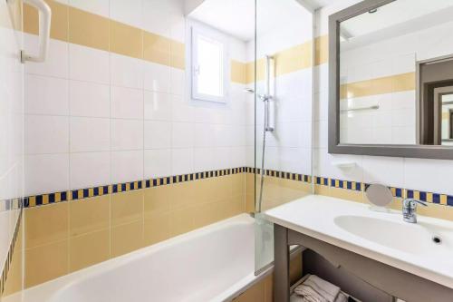 une salle de bain avec une baignoire, un lavabo et un miroir dans l'établissement Résidence Hôtel du Golf de Pont Royal - maeva Home - Appartement 2 pièces 4 personnes climatisé - Sélection MAE-2504, à Mallemort
