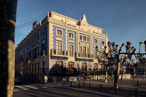 a large white building with a clock on it at Puente Colgante Boutique Hotel in Portugalete