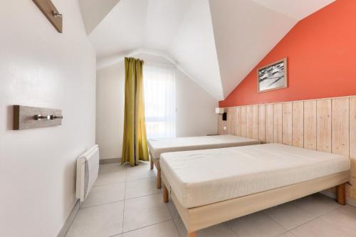 deux lits dans une chambre avec un mur orange dans l'établissement Le Domaine du Bois de la Grée - maeva Home - Maison 3 pièces 6 personnes - Sélection MAE-7904, à Pornichet