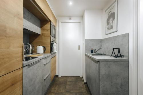 a kitchen with white walls and a gray counter top at Cozy & comfortable apt walking anywhere you want SEN in Prague