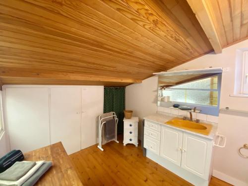 a bathroom with a sink and a wooden ceiling at Kerderff, longere entre plage et foret, TK30 in Carnac
