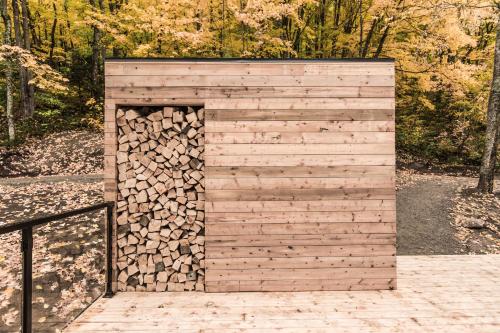 a wooden shed with a pile of fire wood at Dômes Charlevoix in Petite-Rivière-Saint-François