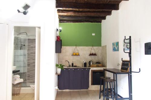 a kitchen with a blue counter and a green wall at La Nicchia in Cagliari